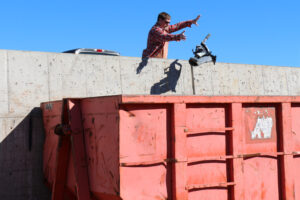 Customer drops waste into a Materials Recovery Center waste bin