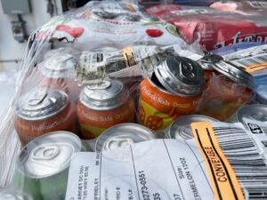 Colorful soda cans burst out of their packaging, aluminum ripping apart at the seams