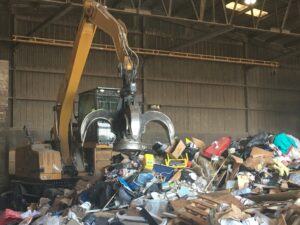 magnetic grapple claw moving to grab garbage